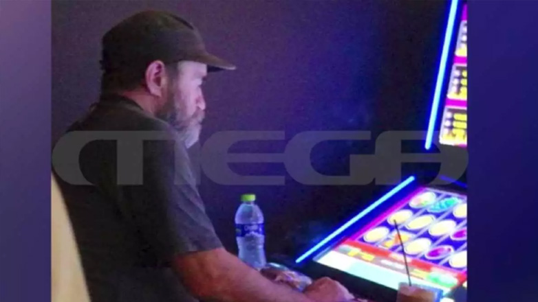 Φωτογραφία δείχνει τον Πολυχρονόπουλο να παίζει φρουτάκια σε πρακτορείο