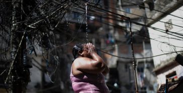 Καύσωνας στο Ρίο ντε Τζανέιρο: Μια γυναίκα δροσίζεται σε ένα δημόσιο ντους στη φαβέλα Ροσίνια