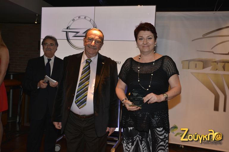 Ο Τριαντάφυλλος Τσουλφάς δίνει το βραβείο στην υπεύθυνη επικοινωνίας της GM Hellas, Αμαλίας Γιαννακοπούλου...