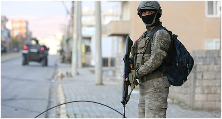 Στρατιώτης επιβλέπει την απαγόρευση της κυκλοφορίας στους έρημους δρόμους της Τσίζρε, όπου κυκλοφορούν μόνο θωρακισμένα στρατιωτικά οχήματα