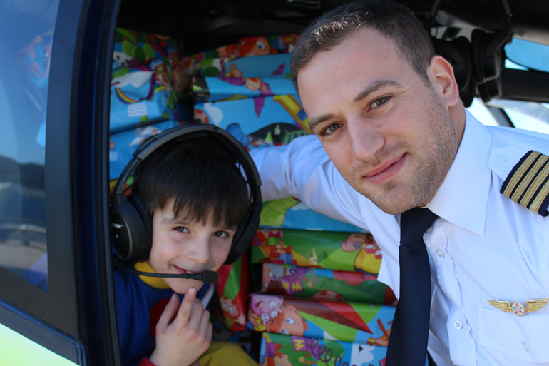 Το... μικρό ξωτικό με τον πιλότο του ελικοπτέρου που έφερε τον Άγιο Βασίλη και στο... βάθος τα δώρα!!!