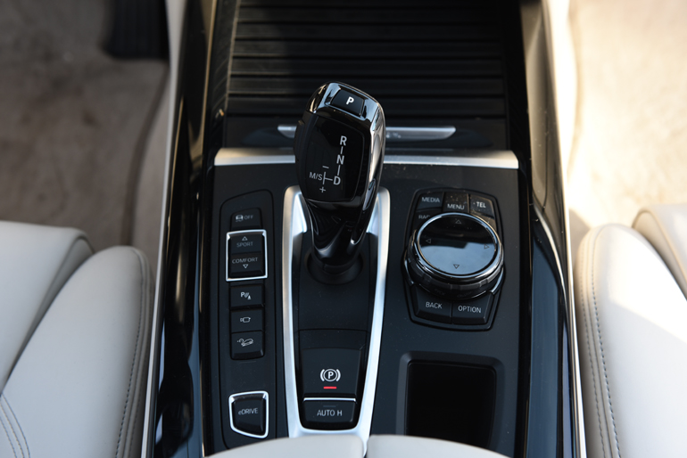 Κουμπιά με τα οποία ρυθμίζεται το στυλ οδήγησης, κουμπί για να ελέγχεις τον τρόπο χρήσης του ηλεκτροκινητήρα, περιστροφικός διακόπτης για τον έλεγχο της κεντρικής οθόνης στην κονσόλα, λεβιές για το αυτόματο κιβώτιο κ.ά.