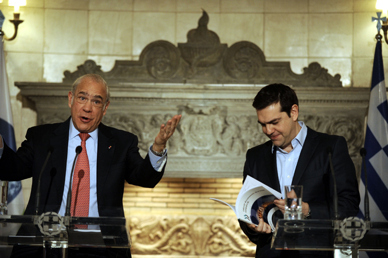 Ο Τσίπρας ξεφυλλίζει την έκθεση ΟΟΣΑ