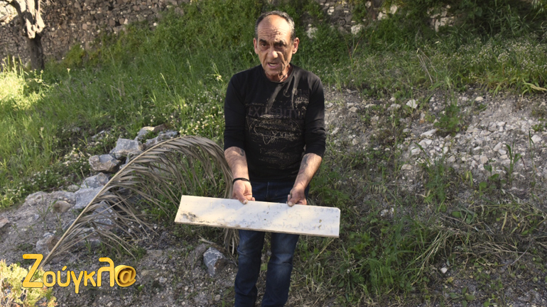 O κ. Χρήστος κρατά μία σβησμένη πλάκα...