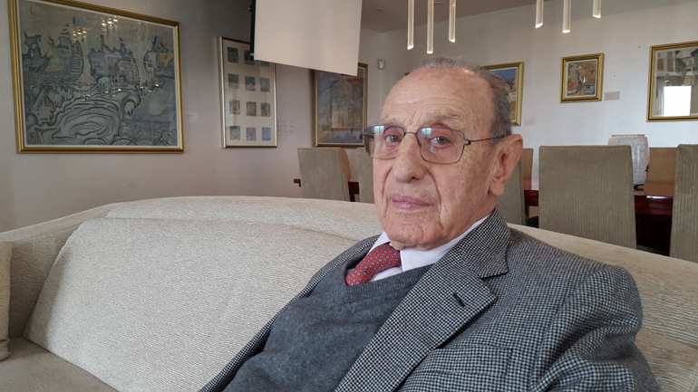 Ο Βασίλης Θεοχαράκης με φόντο ένα από τους αγαπημένους του πίνακες τον οποίο έχει ζωγραφίσει ο Σπύρος Παπαλουκάς...