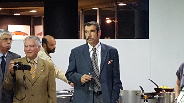 Αριστερά ο Πάνος Φιλιππακόπουλος δείχνει απορημένος με το γεγονός πως  και σήμερα υπάρχουν τέτοια αυτοκίνητα στην Ελλάδα. Στη μέση ο Πάνος Διπλαράκος τραβά φωτογραφίες και αναρωτιέται αν η Huracan έχει ικανοποιητικό χώρο αποσκευών για τα τυριά του super market ενώ ο Θανάσης Παπαθεοδώρου βλέπει Lamborghini και ονειρεύεται Formula 1 στη Δραπετσώνα. 