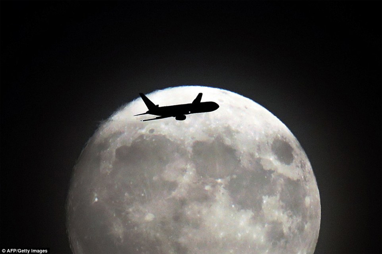 «Μαζί μου έλα...» - Αεροπλάνο πετά πάνω από το δυτικό τμήμα του Λονδίνου με φόντο το επιβλητικό φεγγάρι