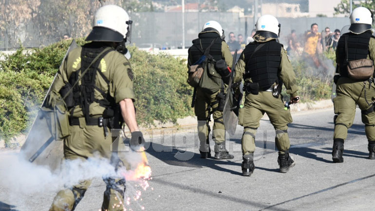 Ένας άνδρας κρατώντας μία φωτοβολίδα που πετάχτηκε 