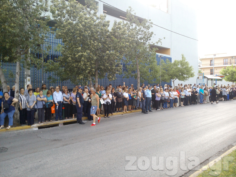 Πιστοί περιμένουν καρτερικά κατά μήκος του δρόμου απ' όπου θα περάσει το Ιερό Λείψανο