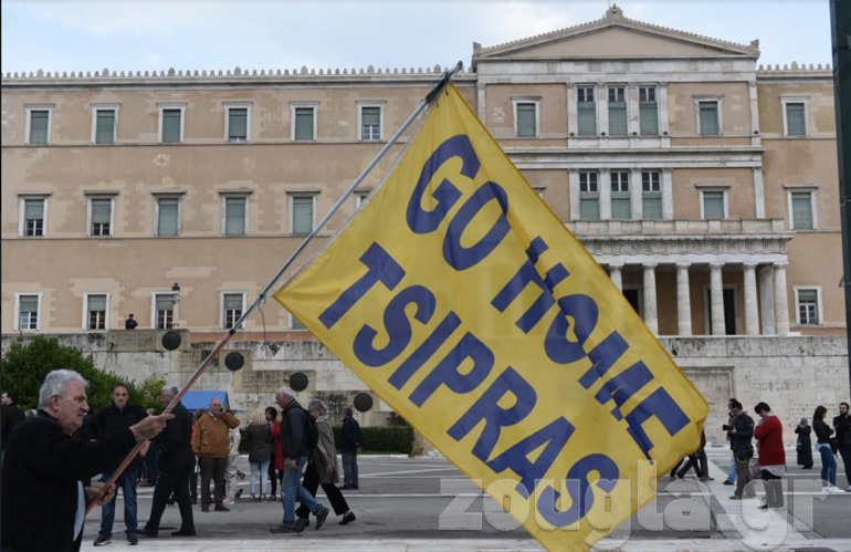 Άνδρας κρατάει πανό που γράφει: Go home Tsipras