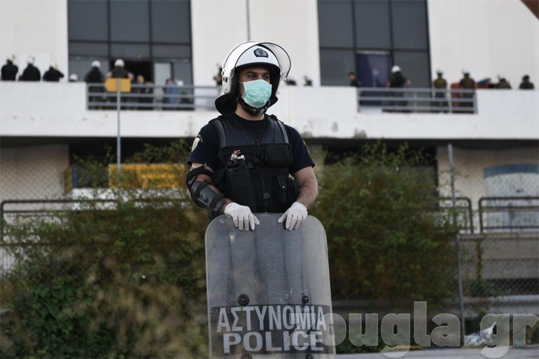 Αστυνομικός... επιτηρεί τους δημοσιογράφους