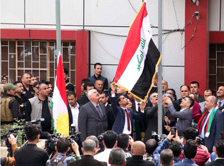 Ο κυβερνήτης του Kirkuk Νajim al-Din Karim υψώνει την κουρδική σημαία δίπλα στην ιρακινή σε κυβερνητικό κτίριο της πόλης, το Μάρτιο (AFP)