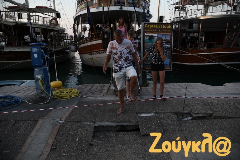 Μια νεαρή τουρίστρια δεν μπορεί να κρύψει την έκπληξη της από τις ζημιές στον προβλήτα