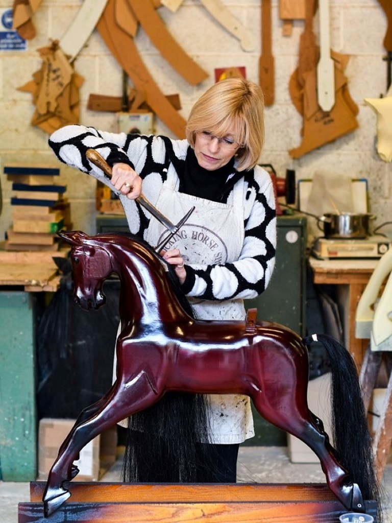 H Julie Tuner, κατασκευάστρια κουνιστών αλόγων, κολλάει τη χαίτη ενός χειροποίητου αλόγου