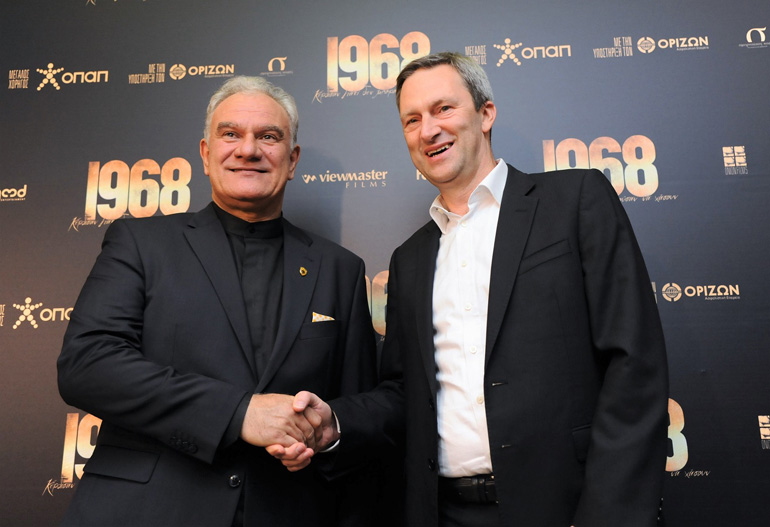 Ο σκηνοθέτης Τάσος Μπουλμέτης με τον Διευθύνοντα Σύμβουλο του ΟΠΑΠ Ντάμιαν Κόουπ