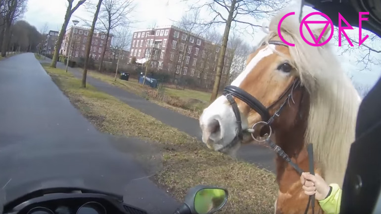 Οδηγός σκούτερ βοηθά μια γυναίκα να πιάσει το άλογό της