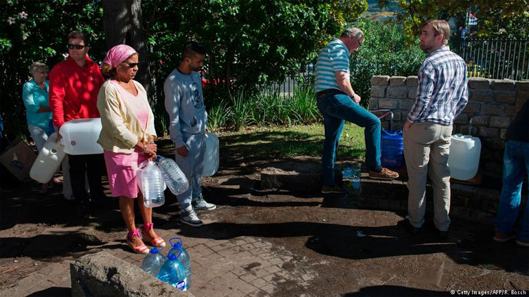 Πολίτες στέκονται στην ουρά για να γεμίσουν τα μπουκάλια τους με νερό