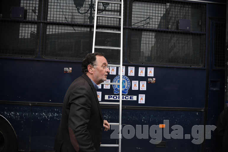 Ο Παναγιώτης Λαφαζάνης στη σκάλα που έχουν βάλει μπροστά από την κλούβα των ΜΑΤ