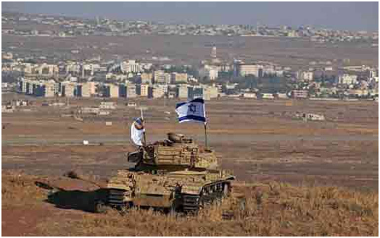 Ισραηλινή σημαία πάνω σε κατεστραμμένο τανκ, (από την εποχή του πολέμου του 1967), σε δεσπόζουσα θέση, στα σύνορα με την Συρία, όπως διαμορφώθηκαν μετά την κατάληψη στο Γκολάν (AFP Photo)