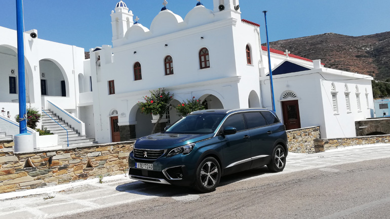 Με φόντο μία από τις εκατοντάδες εκκλησίες της Τήνου