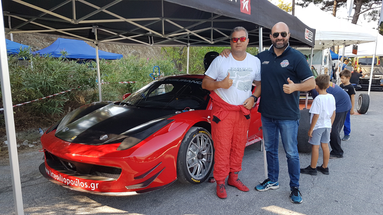 Ο Γιώργος Καραμέρης (δεξιά) με τον οδηγό αγώνων Παναγιώτης Ηλιόπουλο και φόντο την Ferrari με την οποία τρέχει