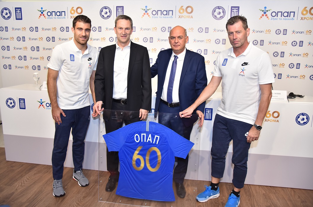 (από αριστερά προς τα δεξιά): Σωκράτης Παπασταθόπουλος – Αρχηγός Εθνικής Ομάδας Ποδοσφαίρου, Ντάμιαν Κόουπ - Διευθύνων Σύμβουλος ΟΠΑΠ, Βαγγέλης Γραμμένος - Πρόεδρος ΕΠΟ, Μίκαελ Σκίμπε - Προπονητής Εθνικής Ομάδας Ποδοσφαίρου