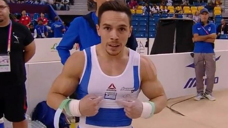 O Λευτέρης Πετρούνιας δείχνει πανευτυχής το εθνόσημο μετά το τέλος του εκπληκτικού προγράμματός του