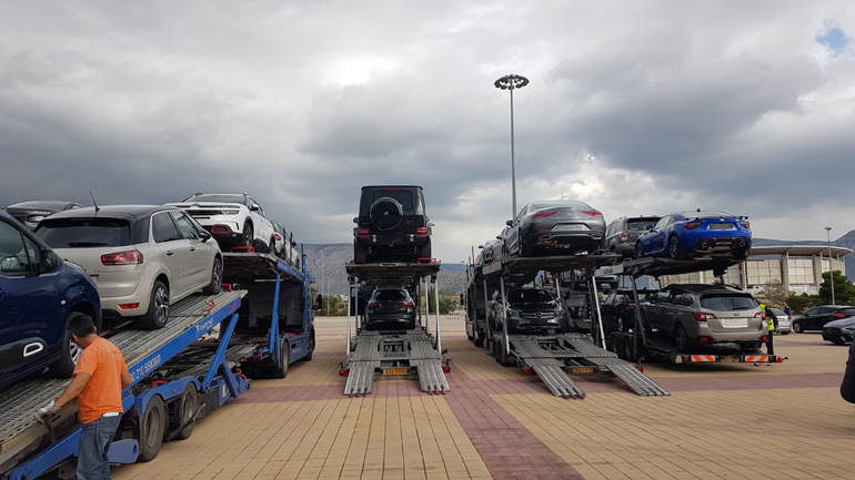 Τα αυτοκίνητα φτάνουν με νταλίκες στο χώρο της έκθεσης...