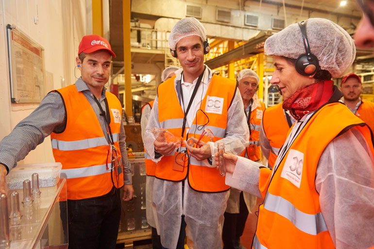 Η Πρέσβης της Βρετανίας  και ο Περιφερειάρχης Στερεάς Ελλάδας κρατώντας φιάλες αναψυκτικών με ανακυκλωμένο PET, που πρώτη στην Ελλάδα παράγει η Coca-Cola Τρία Έψιλον 
