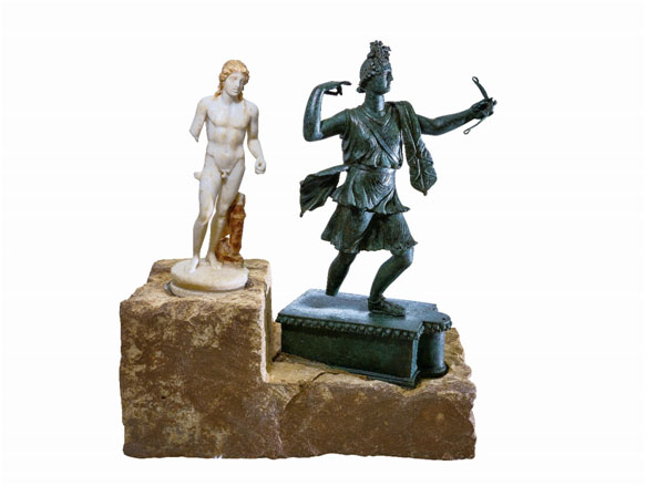  Σύνταγμα χάλκινου γλυπτού Αρτέμιδος και μαρμάρινου γλυπτού Απόλλωνος επάνω σε λίθινη βαθμιδωτή βάση. Άπτερα, 1ος - 2ος αι. μ.Χ.