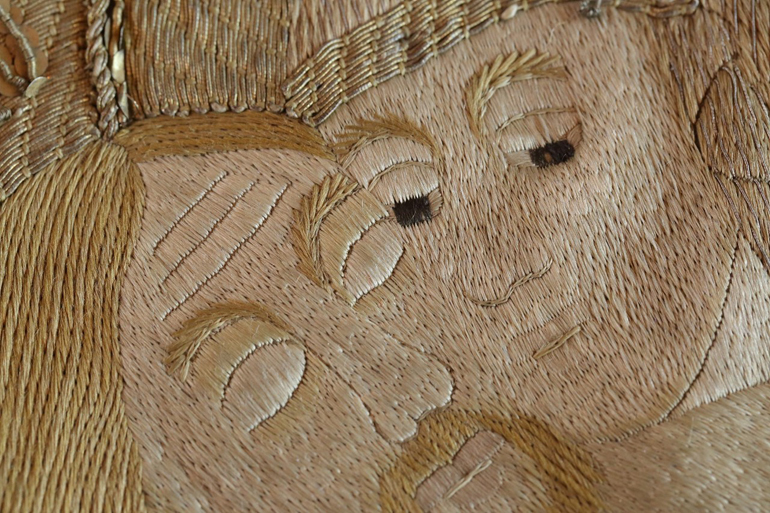 Τα κύρια πρόσωπα του Θείου Δράματος, ο Χριστός και η Θεοτόκος, λεπτομέρεια κεντητού επιταφίου (1733). Αναδεικνύονται η άψογη τεχνική και η χρονοβόρα εργασία δημιουργίας του έργου. Αποδίδεται σε εργαστήριο της Βιέννης