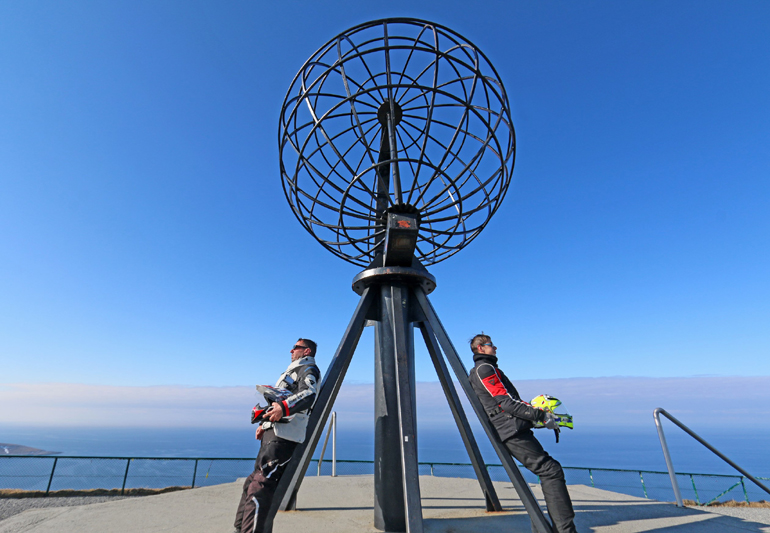 Πατέρας και γιος ποζάρουμε ακουμπισμένοι στην υδρόγειο σφαίρα του Nordkapp