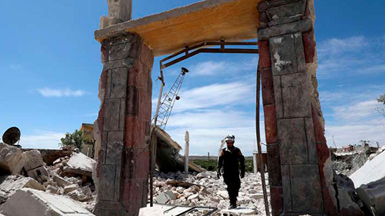 Μέλος της Συριακής Πολιτικής Άμυνας (Λευκά Κράνη) επιθεωρεί τα ερείπια μετά από βομβαρδισμούς από τις δυνάμεις του συριακού καθεστώτος και τους συμμάχους τους στο χωριό Maarit Sin στην ύπαιθρο της επαρχίας Idlib στις 11 Μαΐου 2019.