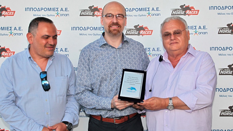  O Chief Technology Officer του ΟΠΑΠ, Michele Fusella και ο Applications Director του ΟΠΑΠ, Στρατής Βαλαβάνης απονέμουν το Τρόπαιο ΚΙΝΟ ΣΤΑ SELF SERVICE TERMINALS στον ιδιοκτήτη του ίππου ΣΠΑΡΤΗ Δημήτρη Παρασκευόπουλο.