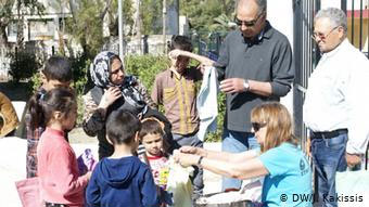 Η Ματίνα Κατσίβελη, μέλος του Δικτύου Αλληλεγγύης Λέρου, μοιράζει ρούχα σε πρόσφυγες