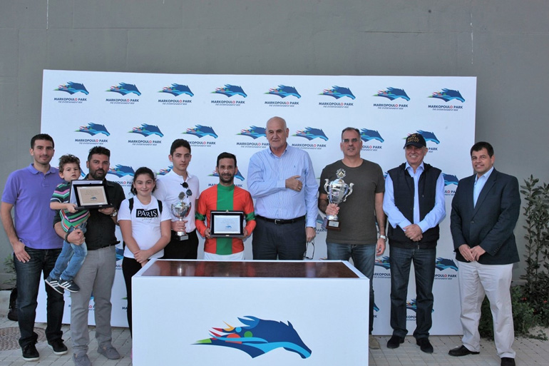 Από αριστερά ο Project Manager της ΙΠΠΟΔΡΟΜΙΕΣ Α.Ε. Βύρωνας Κακλόπουλος, ο προπονητής Χρήστος Σταύρου με τα παιδιά του Φίλιππο, Χριστιάννα και Άγγελο, ο αναβάτης Μιχάλης Ξυνός, ο Διευθυντής Τεχνικών Υπηρεσιών της ΙΠΠΟΔΡΟΜΙΕΣ Α.Ε.  Γιώργος Αγγελόπουλος, ο συνιδιοκτήτης του ΡΑΝ ΤΟΥ ΔΕ ΧΙΛΣ Μάριος Κουτσομύτης, ο Α’ Αντιπρόεδρος της ΙΠΠΟΔΡΟΜΙΕΣ Α.Ε. Σπύρος Φωκάς και το μέλος της Επιτροπής Ιπποδρομιών Σέργιος Σπασσώφ