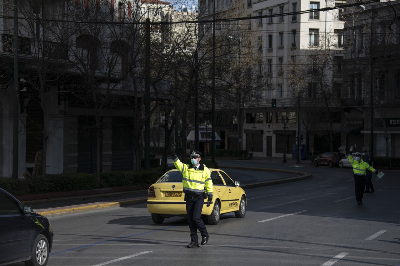 Αστυνομικοί φορώντας μάσκες ελέγχουν τους οδηγούς για τα απαραίτητα έγγραφα