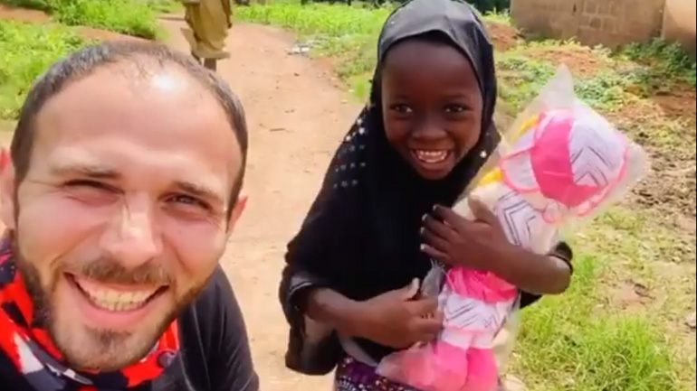Νιγηρία: Άντρας δίνει μια κούκλα σε ένα μικρό κορίτσι