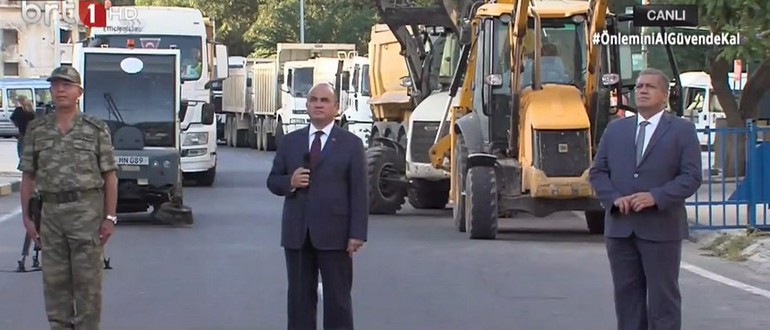 Ο αρχηγός των κατοχικών δυνάμεων (αριστερά), ο αποκαλούμενος Τούρκος πρέσβης στη Β. Κύπρο (στο κέντρο) και ο τουρκοκύπριος δήμαρχος της Αμμοχώστου. Πίσω τους μπουλντόζες και μηχανήματα για την ασφαλτόστρωση