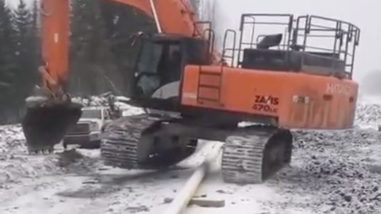 Eκσκαφέας περνά έναν σωλήνα