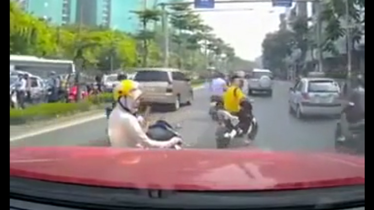 Οδηγός σε σκούτερ σταματά στη μέση του δρόμου για να μιλήσει στο κινητό