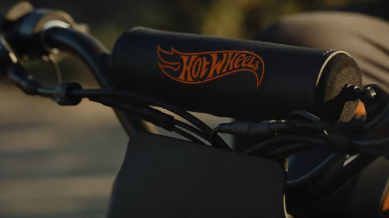 Το λογότυπο της Hot Wheels δεσπόζει στο τιμόνι και το ρεζερβουάρ/μπαταρία του ποδηλάτου.