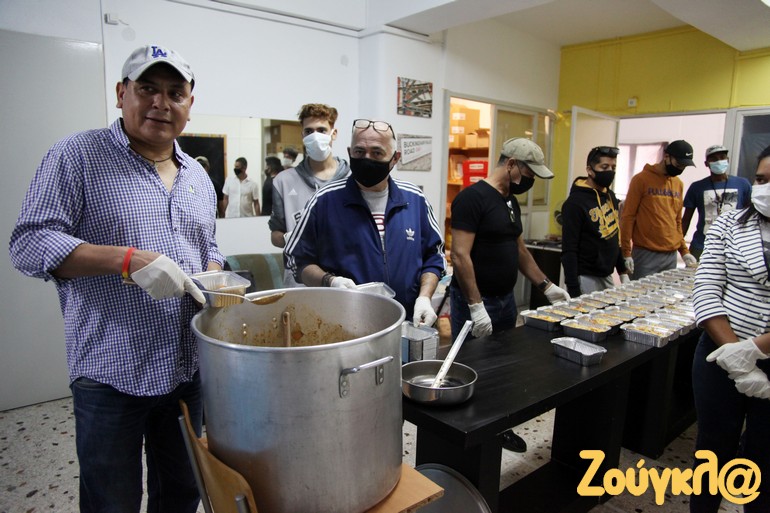 Ο Φελίπε μόλις έχει ετοιμάσει το φαγητό το οποίο βάζει σε κεσεδάκια - Δίπλα του εθελοντές