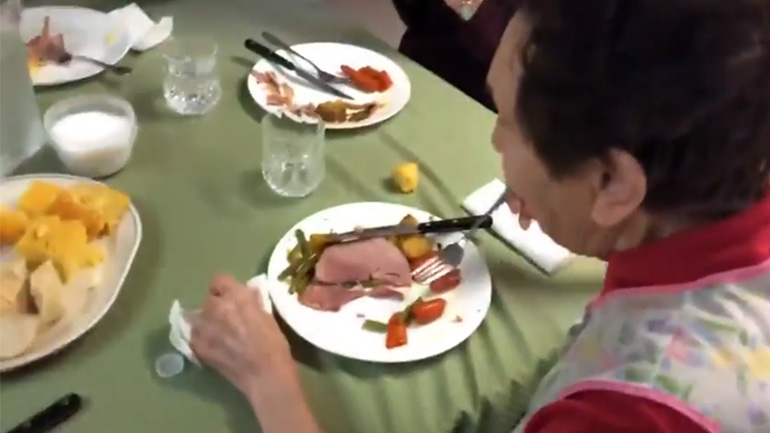 Η γιαγιά ταΐζει τον σκύλο κάτω από το τραπέζι