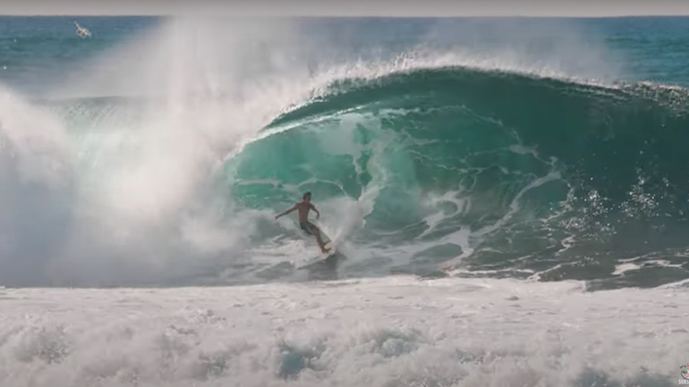 Μια φάλαινα πηδάει πίσω από έναν σέρφερ