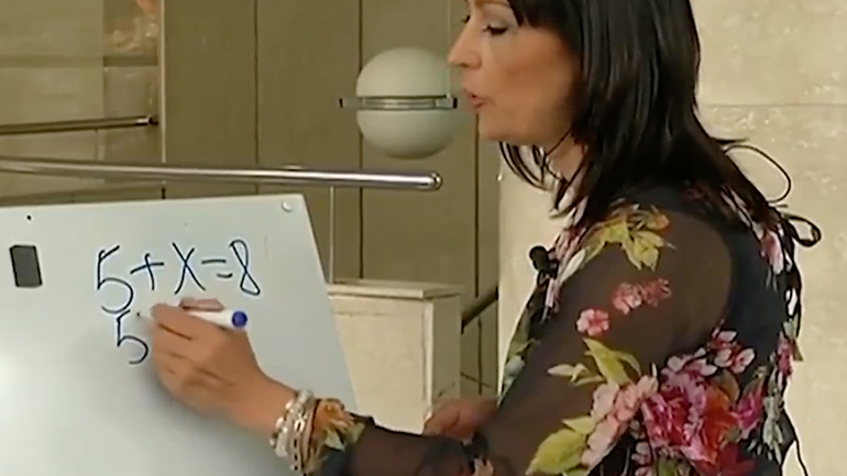 Παρουσιάστρια λύνει μια μαθηματική εξίσωση