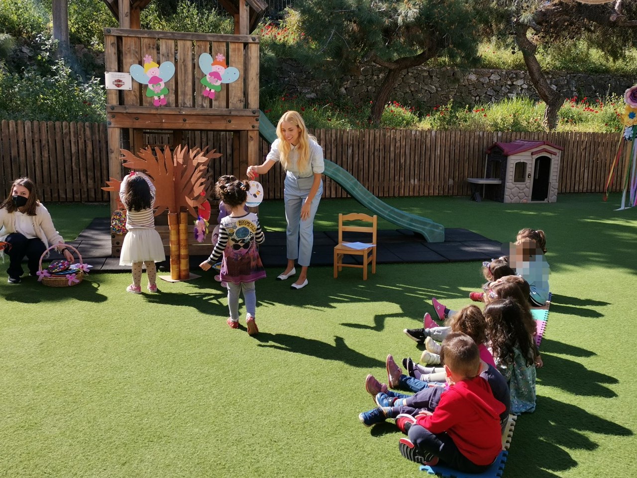 Η πρέσβειρα της Ένωσης "Μαζί για το Παιδί" Δούκισσα Νομικού κρεμάει μαζί με τα παιδιά  της Παιδικής Στέγης στο δέντρο τις πασχαλινές τους κατασκευές