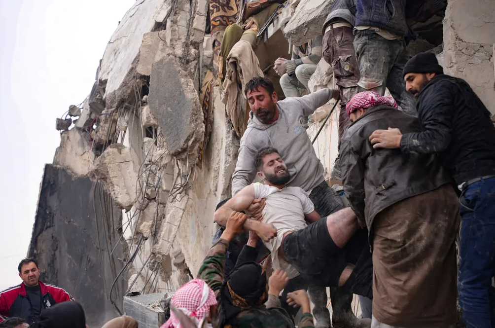 Κάτοικοι ανασύρουν τραυματία από τα ερείπια κτηρίου στην πόλη Τζαντάρης της Συρίας