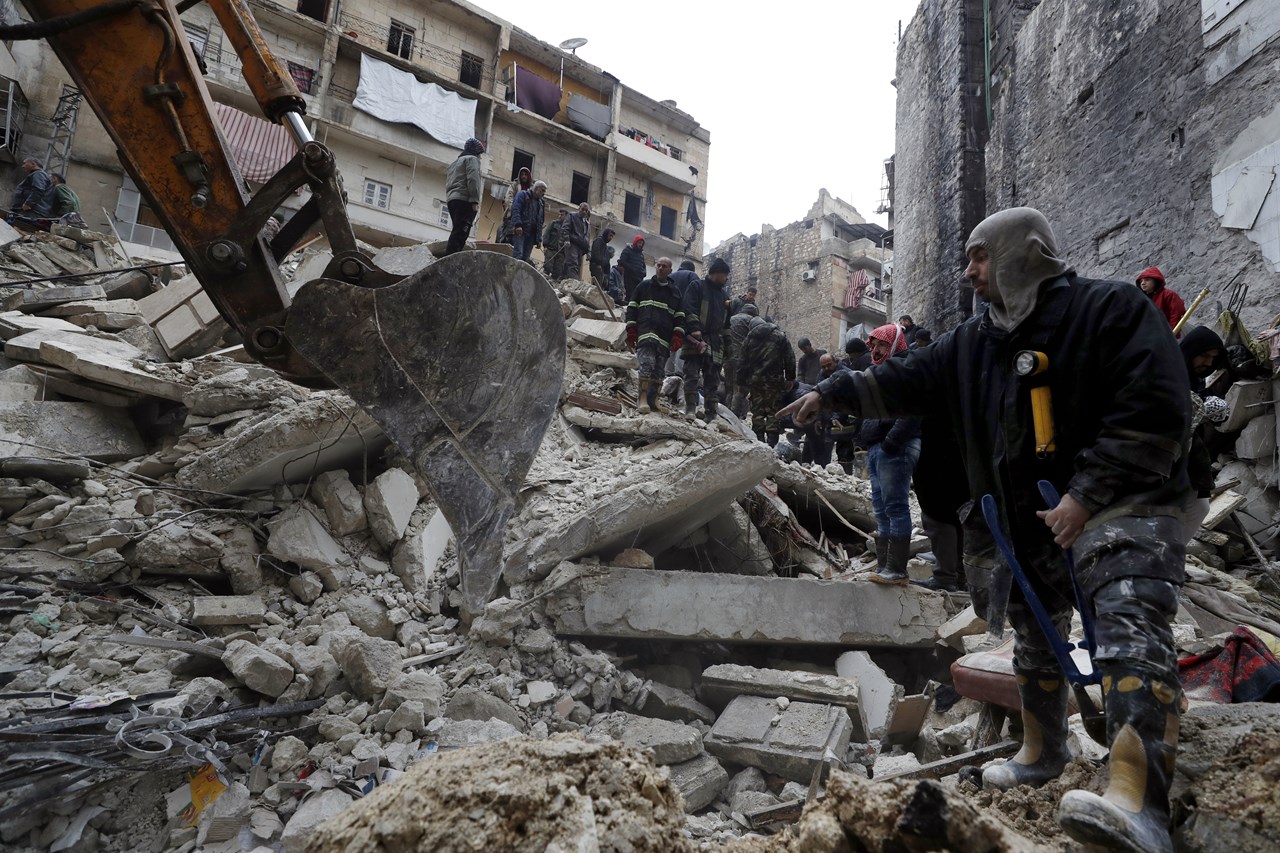 Οι εργαζόμενοι της πολιτικής άμυνας της Συρίας και οι δυνάμεις ασφαλείας αναζητούν επιζώντες στα συντρίμμια κτηρίων στο Χαλέπι