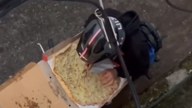 Ντελιβεράς τρώει ένα κομμάτι πίτσα πριν παραδώσει την παραγγελία